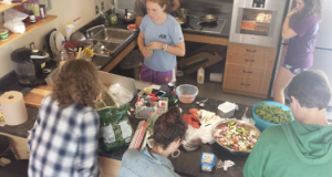 Four students doing meal prep around a counter space.